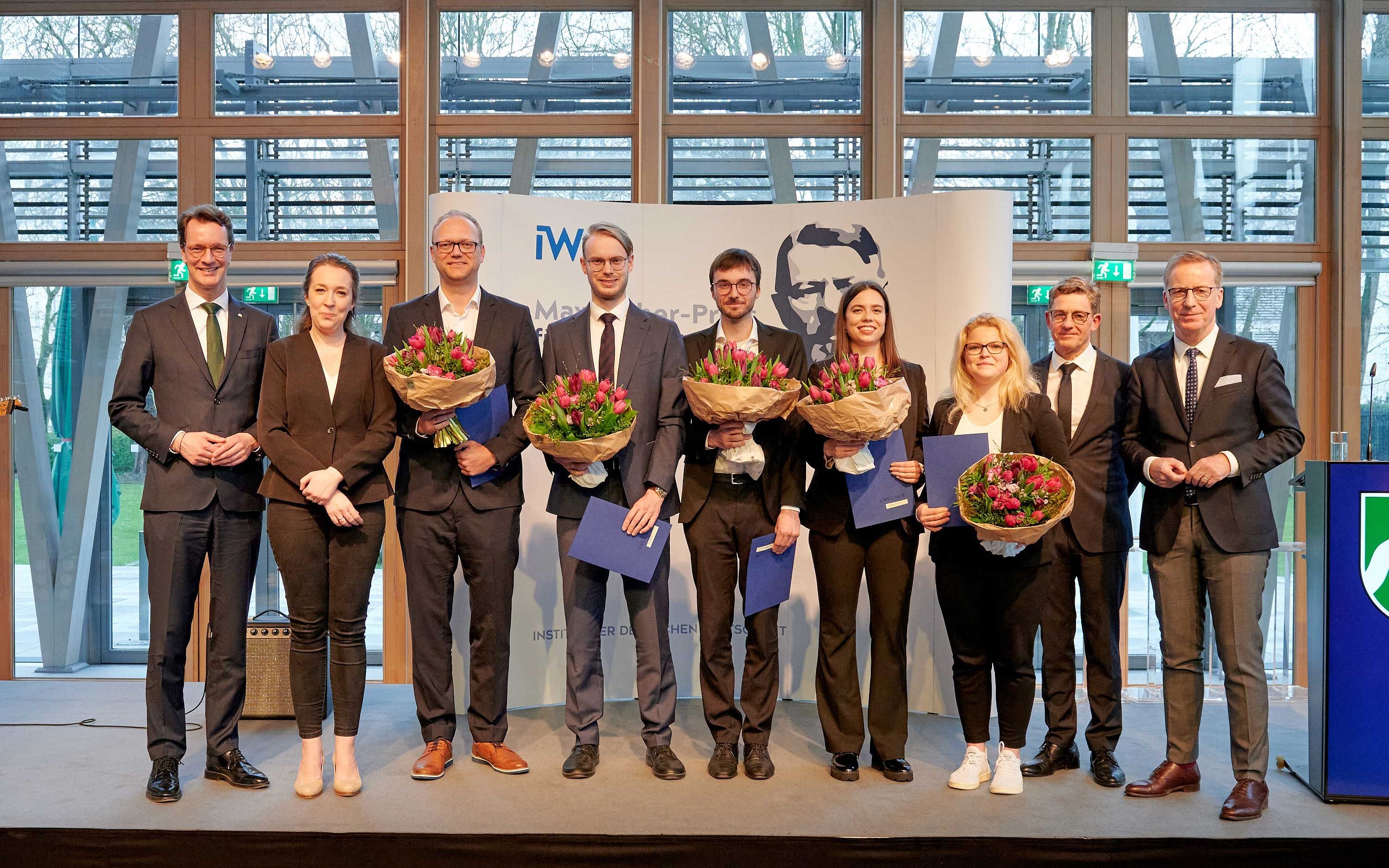 Die Preisträgerinnen und Preisträger, eingerahmt von NRW-Ministerpräsident Hendrik Wüst (l.) und IW-Direktor Michael Hüther. Foto: Kerstin Müller